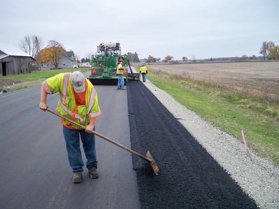 man mixing asphalt outside