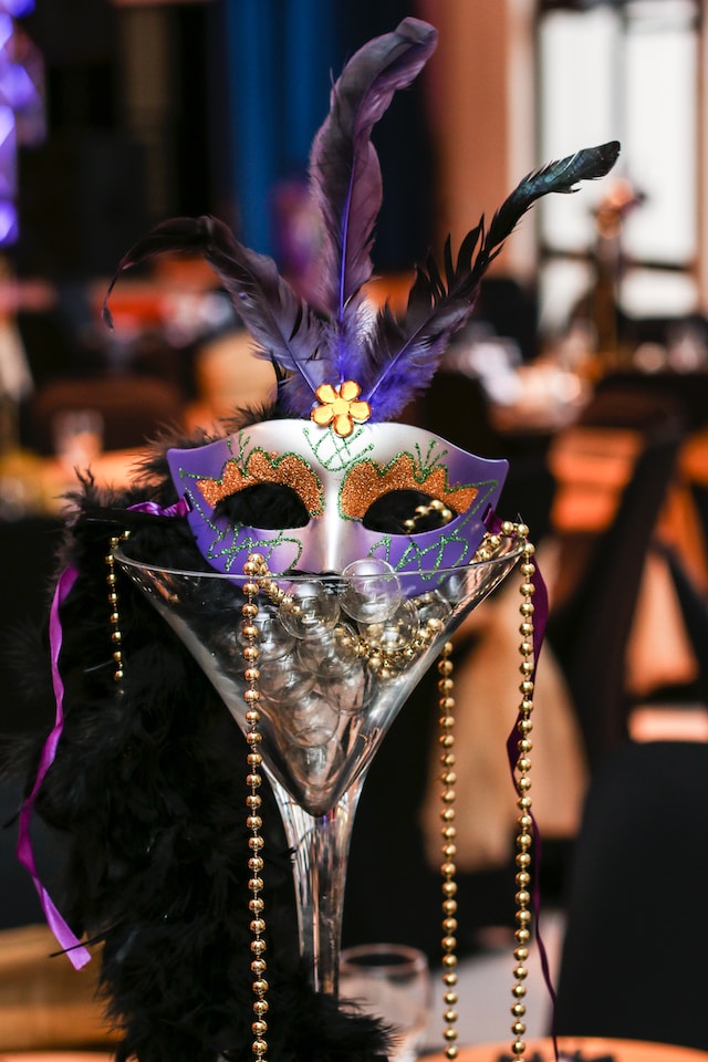 carnival mask in a cocktail glass with beads